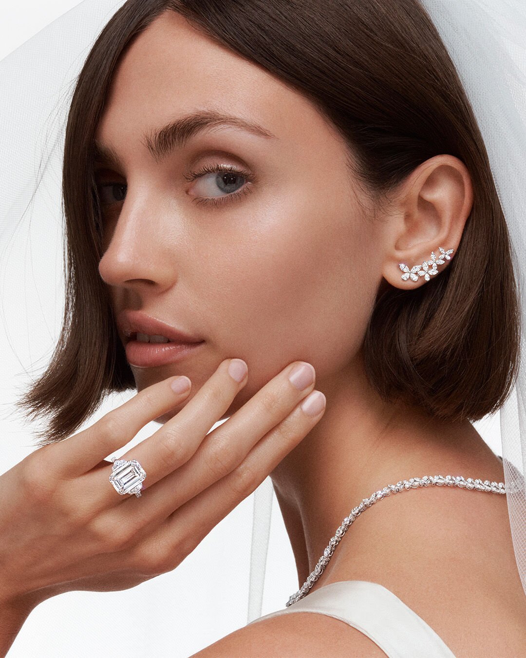 Model wearing Graff Promise Emerald Cut engagement Ring and Graff Butterfly Jewellery